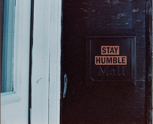 Sign reading "Stay humble"