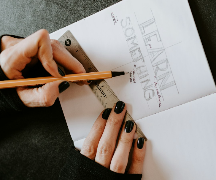 notebook with person building "learn something" like it's a blueprint