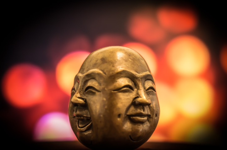 Buddha face with happy on one side and a calm face on the other