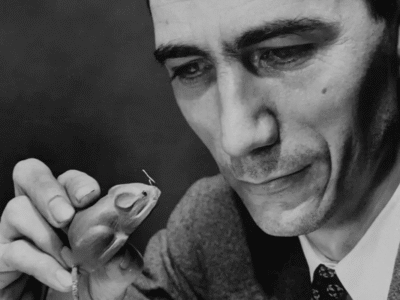 Claude Shannon looking at a mechanical mouse